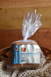 Packaged loaf of whole wheat bread on a wooden surface